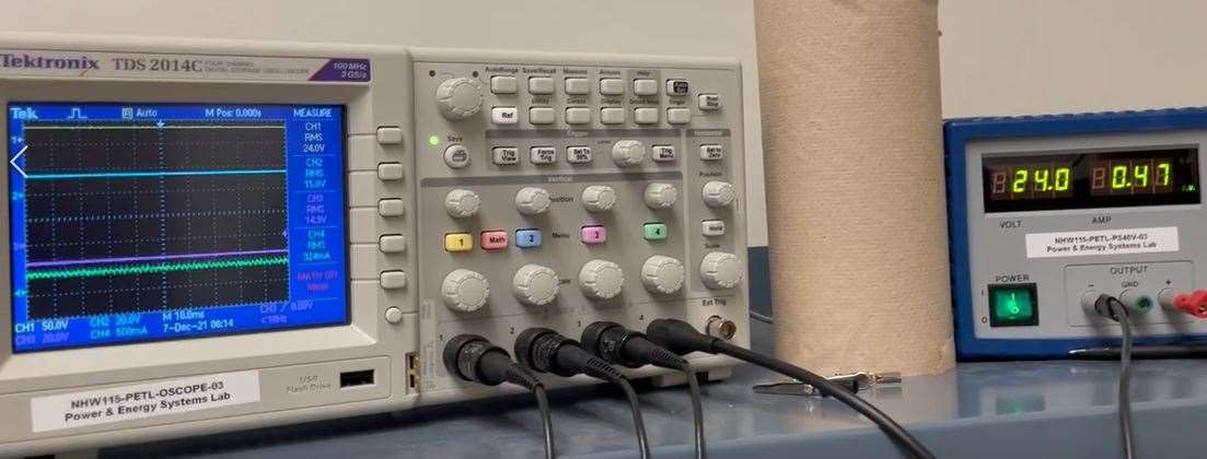 Oscilloscope and bench supply during the 24 V qualification run, with RMS readouts of 24.0 V input and 15.0 V and 14.9 V outputs